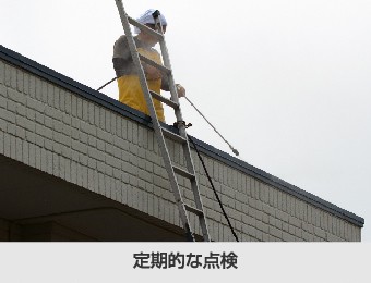 陸屋根の定期点検をする作業員