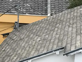 雹の被害によってボロボロになったスレート屋根